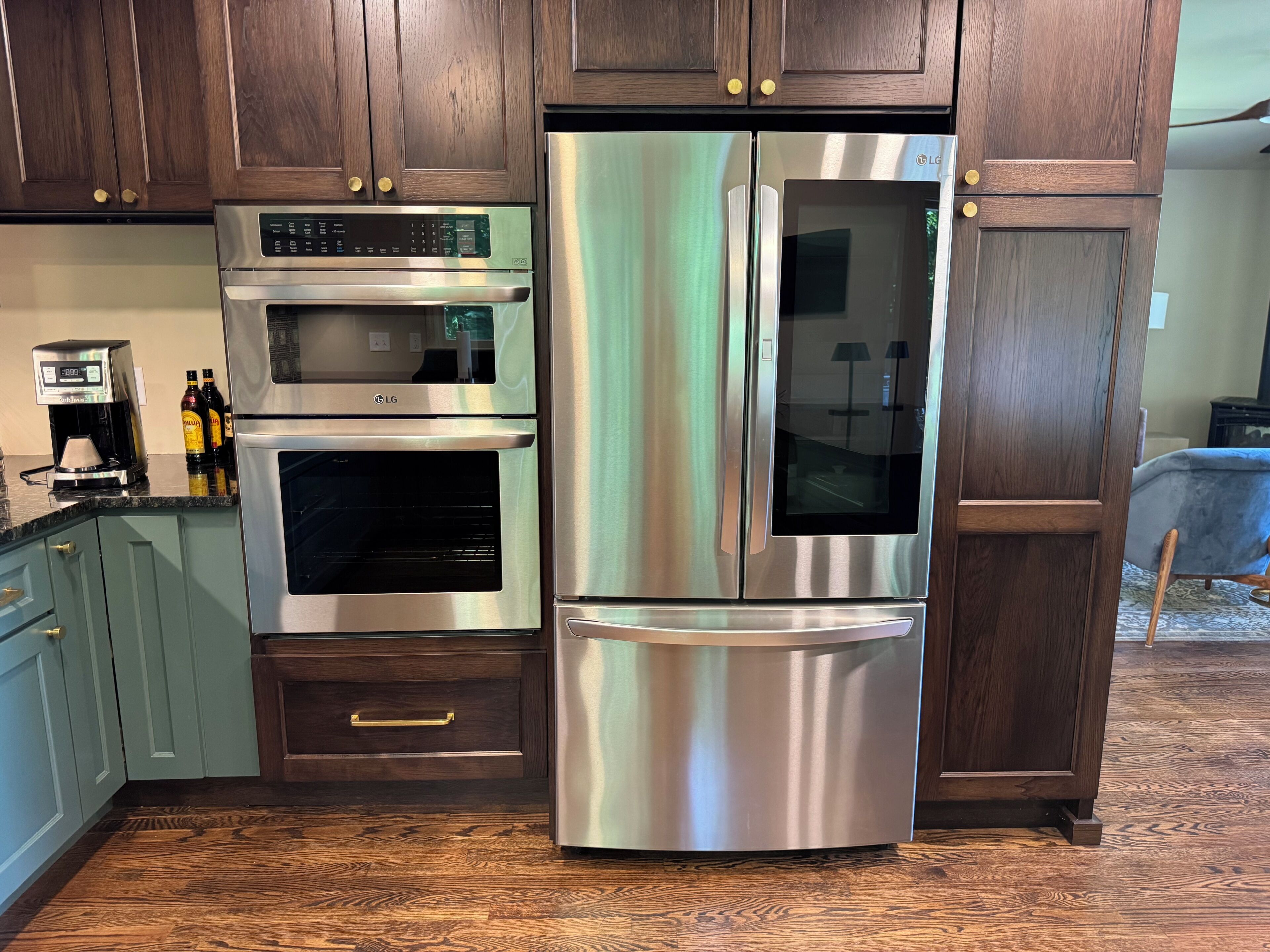 A kitchen with dark wooden cabinets, stainless steel appliances, and a coffee maker.