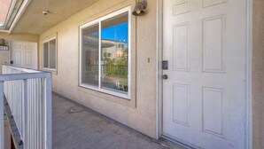 A building exterior with a covered walkway, large windows, and a white door. - Heart of Hillcrest - 4BR Home in Prime Location (San Diego)