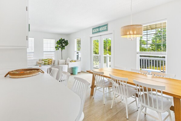 A bright, white interior with a dining area, a sign reading "BEACH HOUSE," and a view of greenery outside. - Seagrove Beach 30A "The Sweet Southern Juan"
Just steps from the Ocean (Santa Rosa Beach)