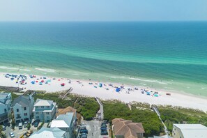 An aerial view of a beach with a row of buildings in the foreground, a clear view of the ocean, and a sandy beach with umbrellas. - Seagrove Beach 30A "The Sweet Southern Juan"
Just steps from the Ocean (Santa Rosa Beach)