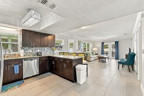 A modern kitchen with dark wood cabinets, a granite countertop, and a dishwasher.