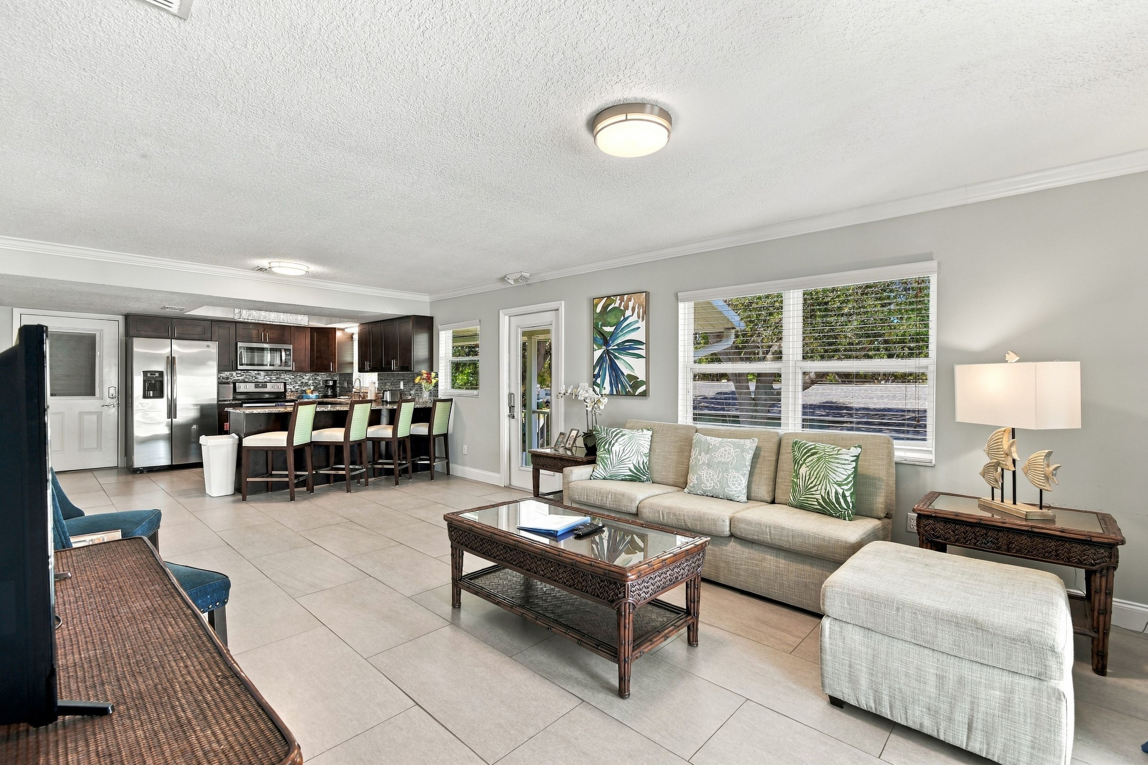 A spacious living room with a sofa, coffee table, and a dining area with chairs.