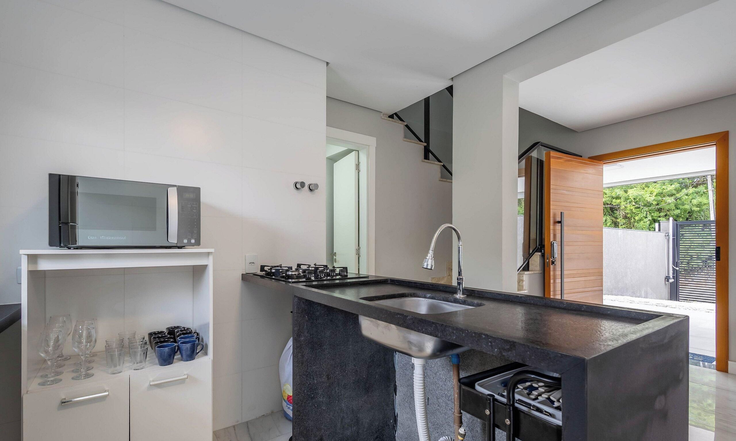 A modern kitchen with a built-in microwave, a gas stove, and a sink.