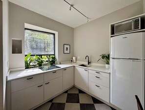 Klassiek appartement | Privékeuken | Een koelkast, kookgerei, borden en bestek