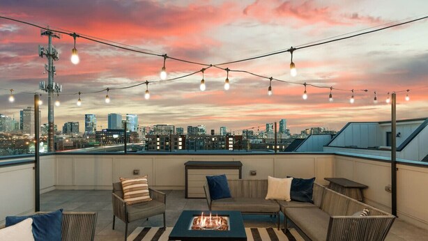 A rooftop terrace with a city skyline view, string lights, and a fire pit. - City View Home Only 1.5 mile to Downtown with Garage and Rooftop (Nashville)