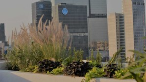 A cityscape with modern skyscrapers, including a building with a blue logo. - Nice loft in excellent area. (Guadalajara)