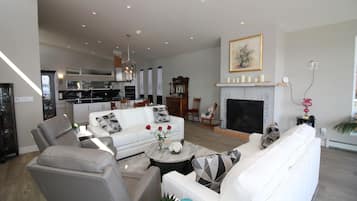 A spacious living room with a white sofa, a coffee table, and a fireplace.