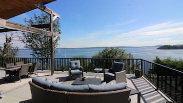 A covered outdoor seating area with wicker furniture and a view of the water.