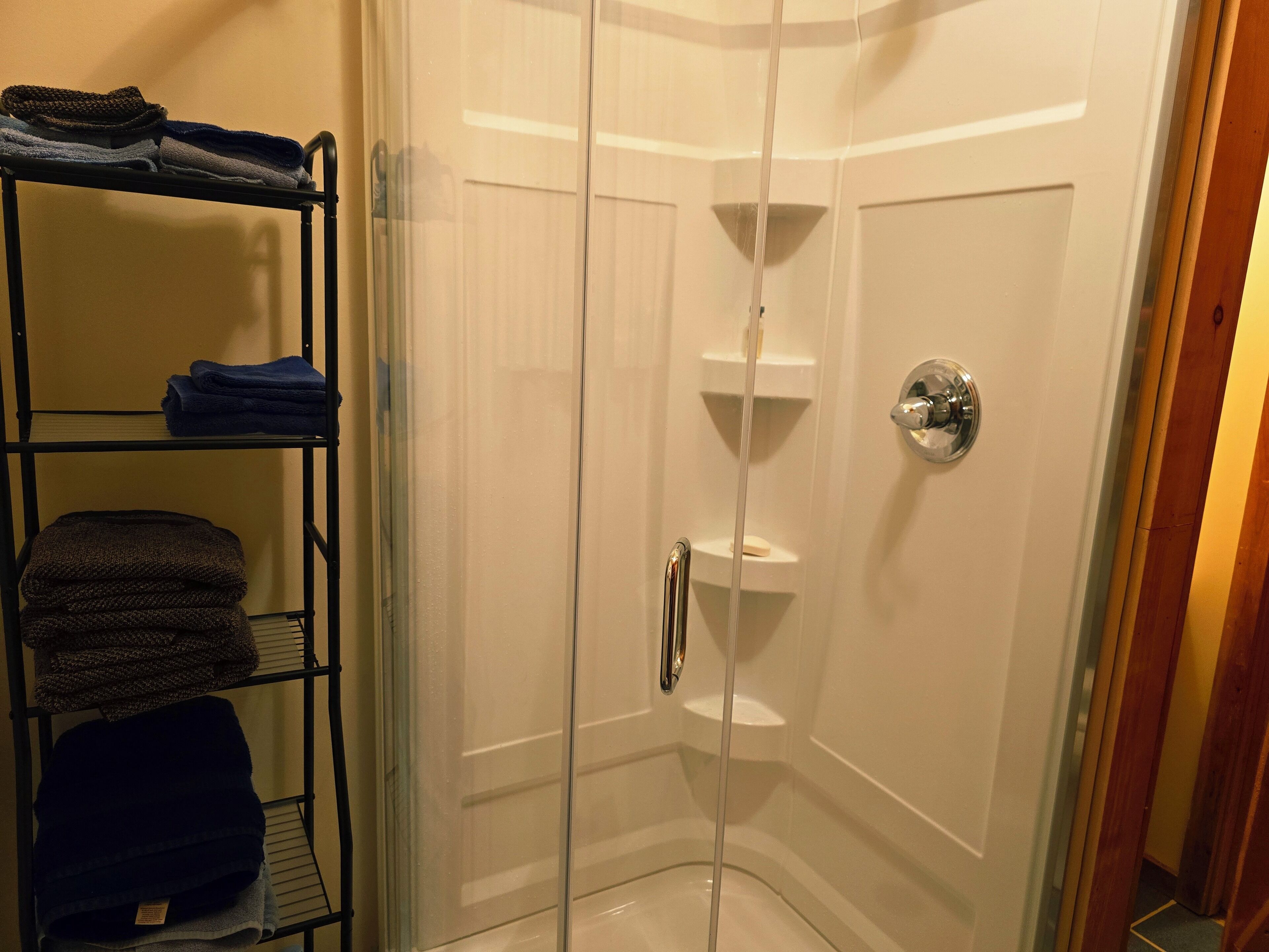 Een douche, handdoeken, zeep, toiletpapier