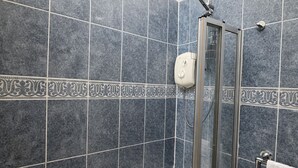 Un baño con bañera, cabina de ducha de cristal y perchero para toallas.