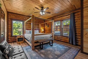 A log cabin bedroom with a four-poster bed, a bench, and a ceiling fan. - 8BR Luxury Lodge w/ Indoor Pool, Hot Tub & Mountain Views, Sleeps 28 (Sevierville)