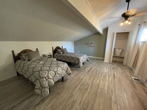 A bedroom with two beds, a ceiling fan, and a wall with a love message. - Private Rooms in Delightful Leander with Salon & Spa Service Options (Leander)