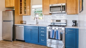 Una cocina moderna con armarios de madera, electrodomésticos de acero inoxidable y encimera azul.