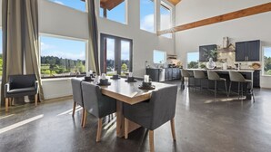 A modern kitchen with dark cabinets, a marble countertop, and a large window. - Waterfront 6-Acres w/ Pickleball, Hot Tub, Cold Plunge, Putting Green, Games! (Broken Bow)