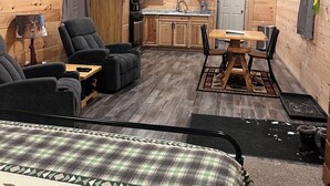 Un intérieur de chalet chaleureux comprenant un coin repas, une cuisine et un espace salon.