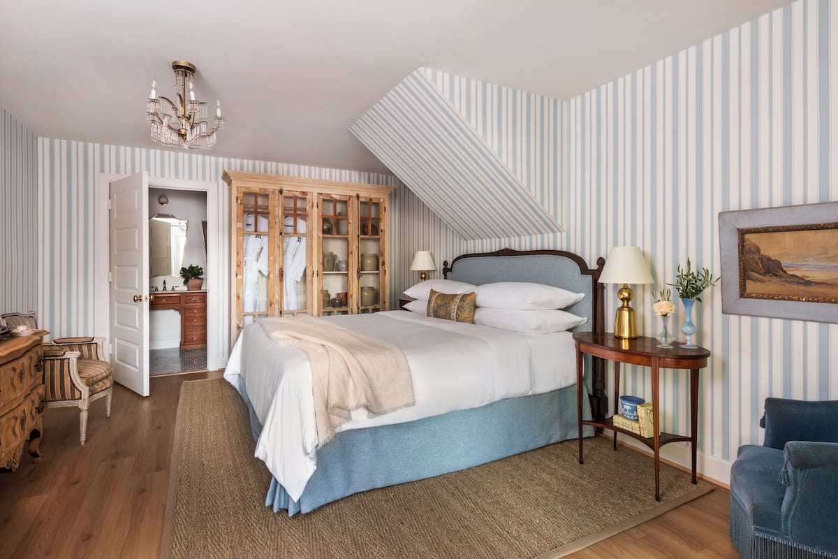 Un dormitorio con una cama, un armario de madera, un escritorio y una silla.