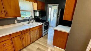 A kitchen with wooden cabinets, a stainless steel range, and a white countertop. - single family home, easy access, safe area (South Bend)