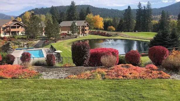 A resort with a swimming pool, manicured gardens, and a view of a lake and mountains. - Enjoy our beautiful two-bedroom condo over Christmas break. (Leavenworth)