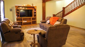 A living room with a sofa set, a TV, and a wooden entertainment center. - Casa Naranja - Casa de 5 Cuartos 6 baños de Lujo y Confort (Ciudad Fernández)