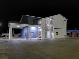 Un edificio de varios pisos con un acceso cubierto y una escalera que conduce a un nivel superior.