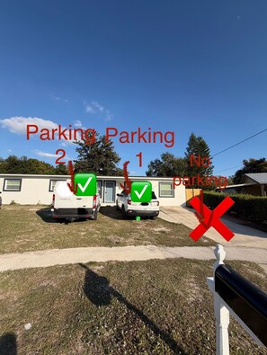 A parking area with two vehicles marked as 'Parking 2' and 'Parking 1' with green check marks, and one vehicle marked as 'No Parking' with a red cross. - A Modern Oasis Near Hard Rock Tampa (Tampa)
