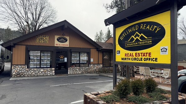 A real estate office with a stone facade, a sign for 'Idyllwild Realty', and a 'Notary Public' sign.