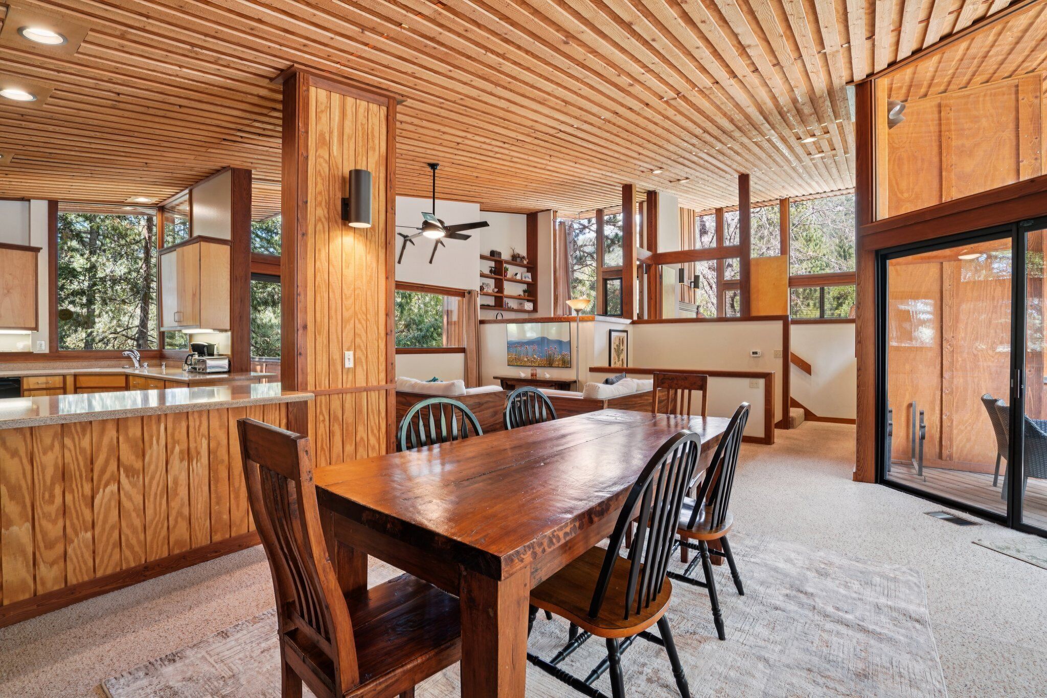 A spacious kitchen with wooden cabinetry, a central island, and a dining area with a large wooden table and chairs.