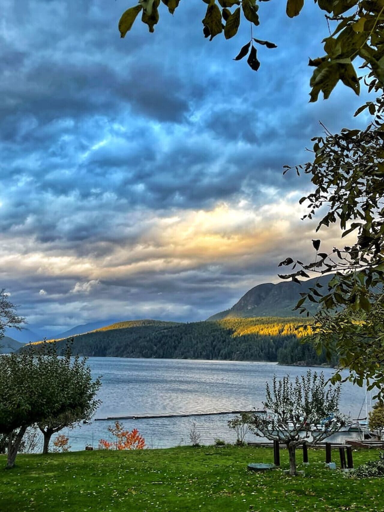 Un lago con montañas al fondo y un cielo nublado.