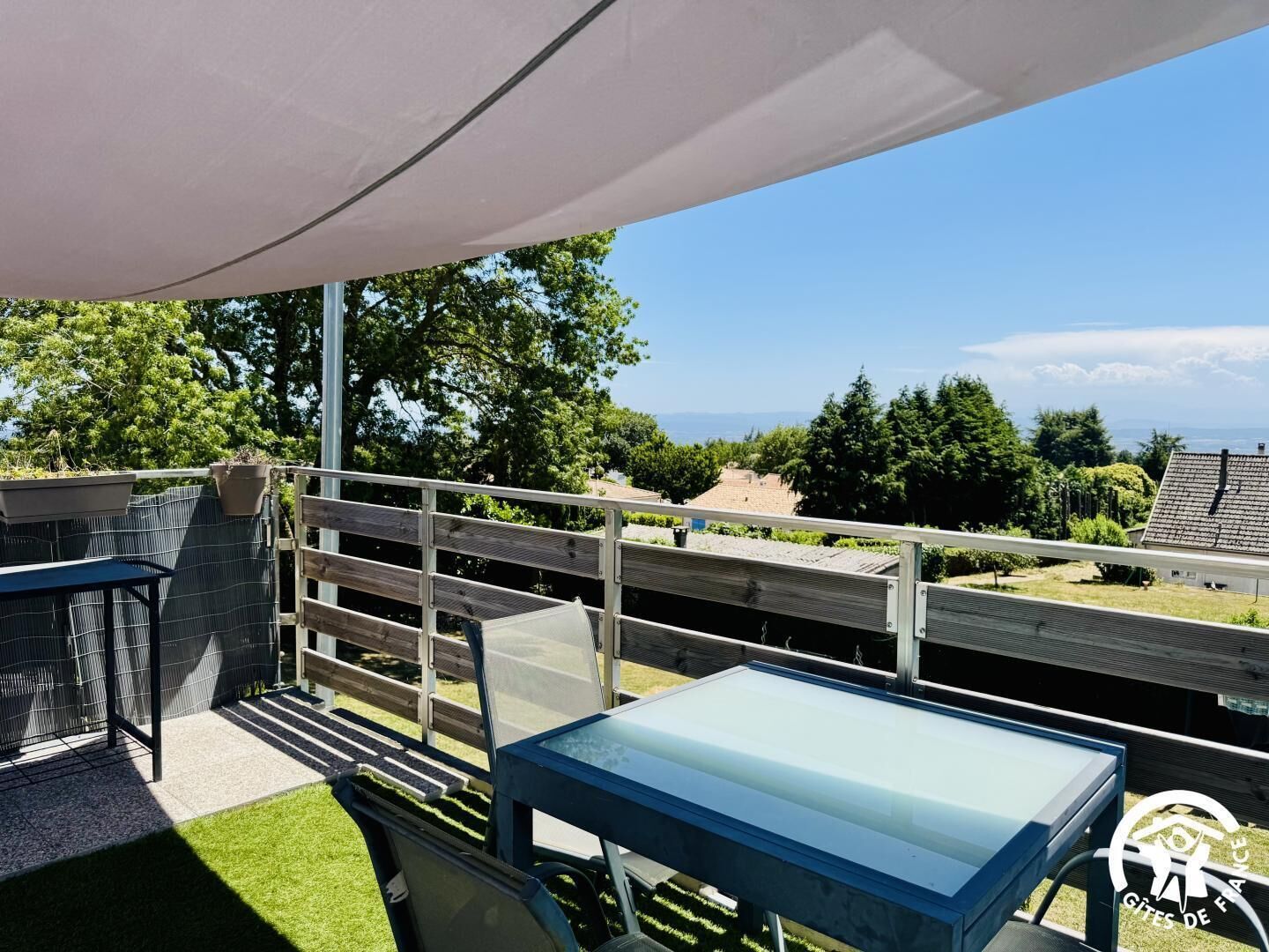 Eine Terrasse mit Tisch und Stühlen, einer Pergola und Blick auf die Landschaft.