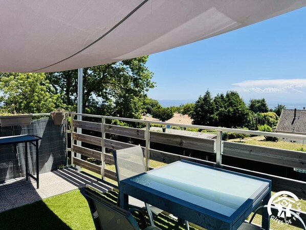 Una terraza con mesa y sillas, una pérgola y vistas del paisaje.