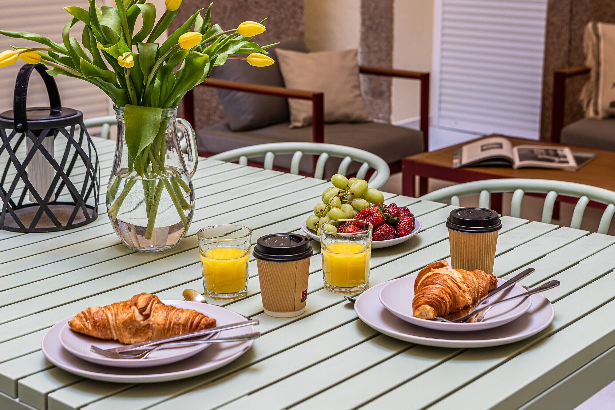 Taula de l'esmorzar amb croissants, suc, cafè i fruita.