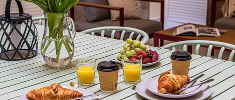 Taula de l'esmorzar amb croissants, suc, cafè i fruita.
