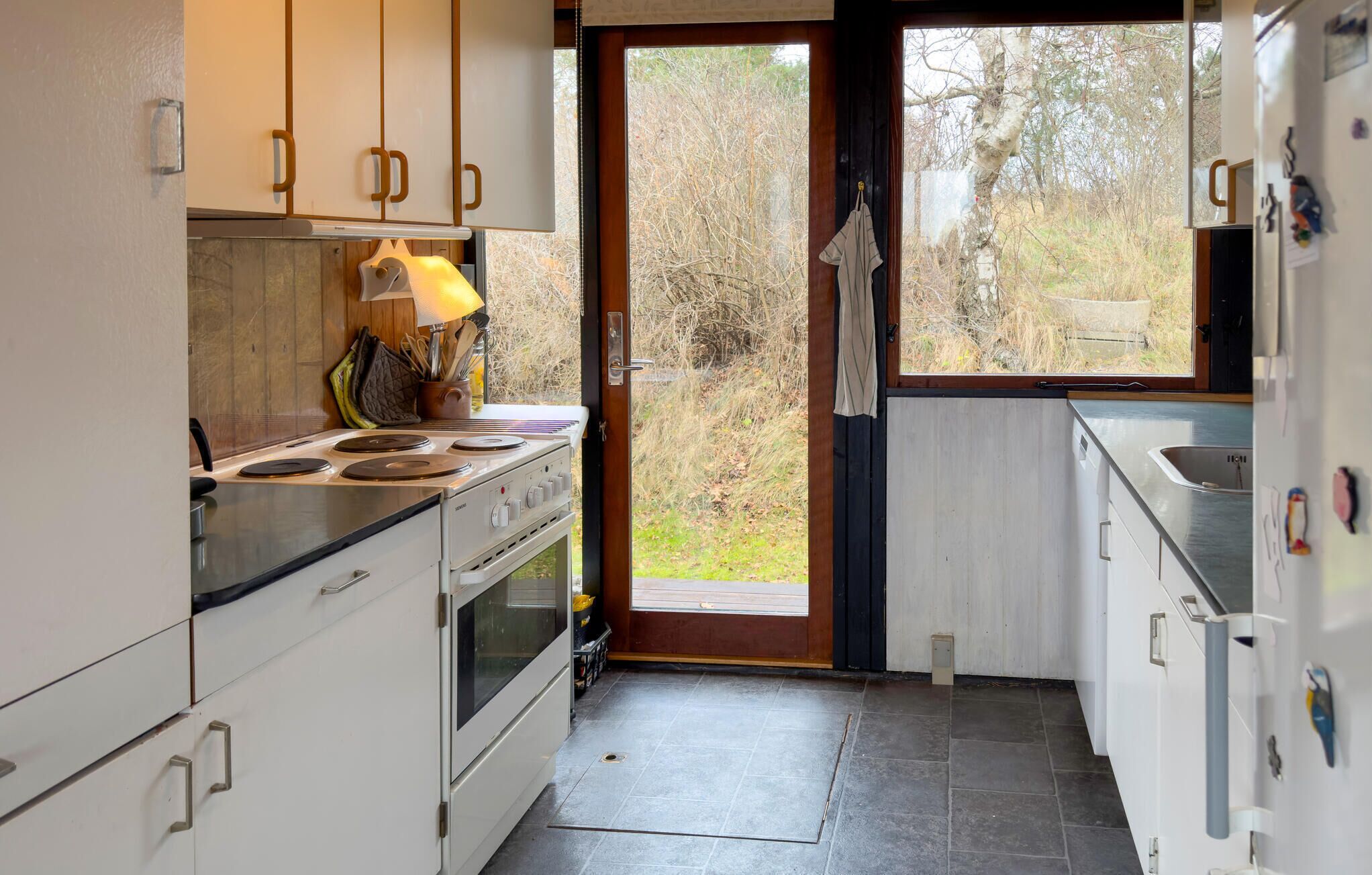 A kitchen with white cabinets, a stove, and a sink.