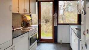 A kitchen with white cabinets, a stove, and a sink. - 3 bedroom stunning home in Knebel (Knebel)