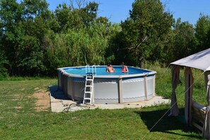 An above-ground swimming pool with a ladder, surrounded by grass and trees. - L'Étang - LA REDORTE - Vacation Rental (LA REDORTE)