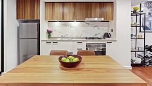 Eine moderne Küche mit einem Holztisch, einer Obstschale und einem Essbereich.