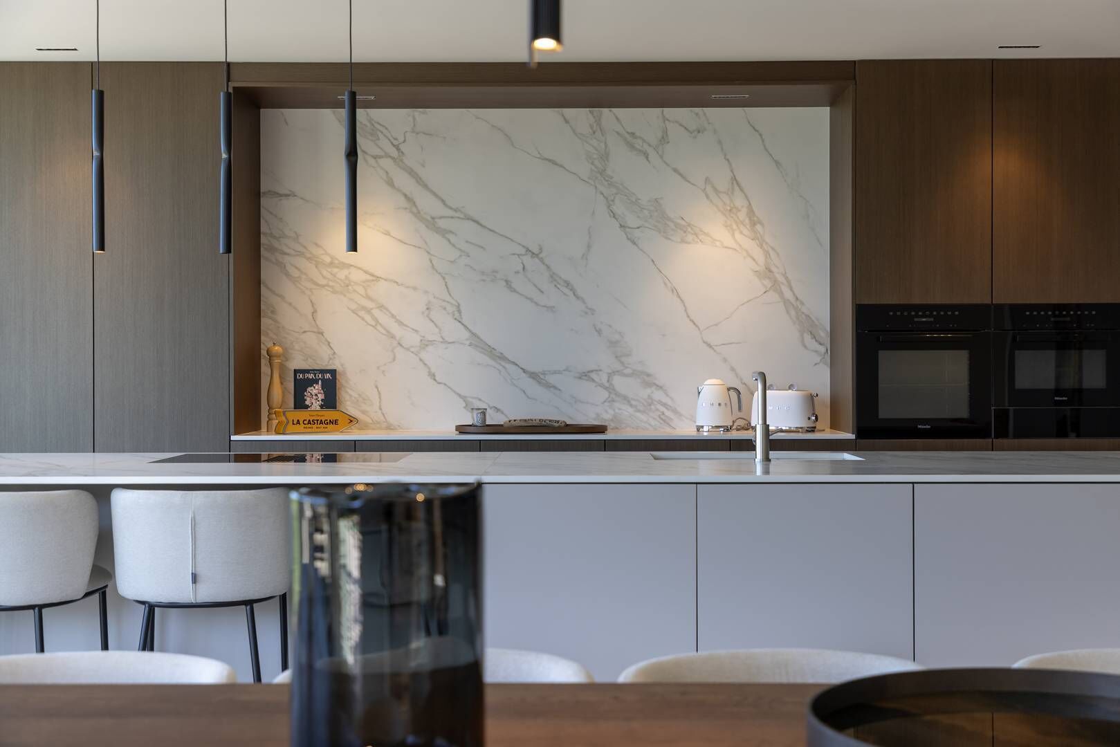 Una cocina moderna con salpicadero de mármol, electrodomésticos de acero inoxidable y un diseño minimalista.