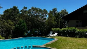 A swimming pool with a circular edge, surrounded by grass and trees. - Bordelago Pucón Playa Privada (Araucanía)