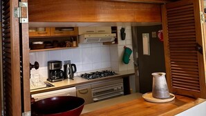 A kitchen with wooden cabinets, a stove, and a sink. - Bordelago Pucón Playa Privada (Araucanía)