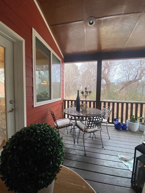 A covered porch with a table and chairs, a potted plant, and a door. - Elegant 1 GUEST ROOM in a Beautiful Home in Clayton, NC  (Clayton)