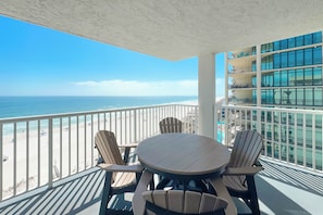 A balcony with a view of the beach and ocean, featuring a round table and four chairs. - Romar Tower 9D | Low Density | Beachfront | Outdoor Pool | My Beach Getaways (Orange Beach)