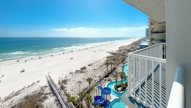A beach view from a balcony with a pool and a lifeguard stand. - Romar Tower 9D | Low Density | Beachfront | Outdoor Pool | My Beach Getaways (Orange Beach)