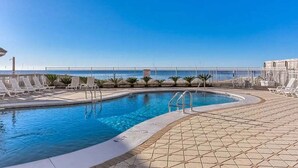 A swimming pool with lounge chairs and a view of the sea. - Romar Tower 9D | Low Density | Beachfront | Outdoor Pool | My Beach Getaways (Orange Beach)