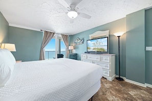 A bedroom with a large bed, a ceiling fan, a television, and a view of the outdoors. - Romar Tower 9D | Low Density | Beachfront | Outdoor Pool | My Beach Getaways (Orange Beach)