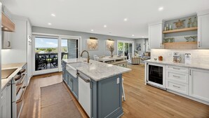 A modern kitchen with a large island, built-in appliances, and a view to the outdoors. - Unbeatable, OCEANFRONT Views - 4 bedroom Pelican Watch, FULLY RENOVATED! (Seabrook Island)