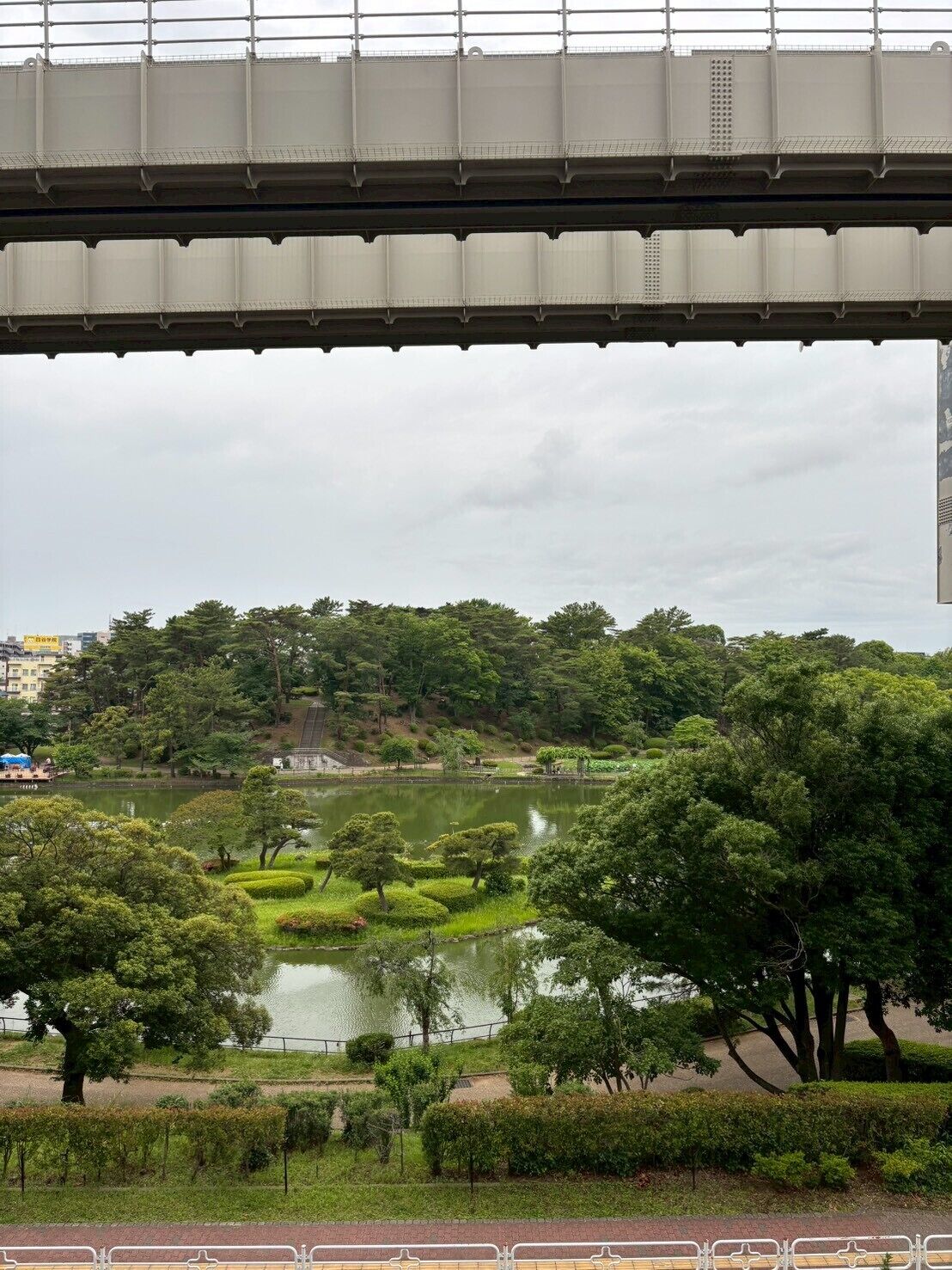 A bridge with a view of a park and a lake.