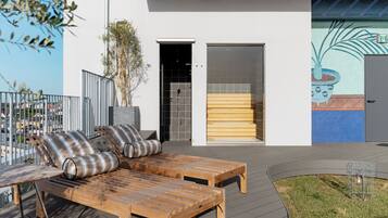 A modern outdoor seating area with wooden furniture and a view of the cityscape.