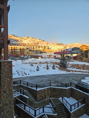 Ein Hotel mit Steinfassade, einer Seilbahn und einer schneebedeckten Landschaft.