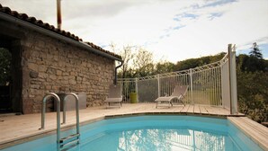 A swimming pool with a stone wall and metal railing, surrounded by trees and a clear sky. - La Masure - LARROQUE (LARROQUE)