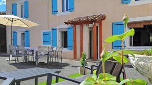 A building with multiple windows, outdoor seating, and a pergola. - Le gîte du Vigneron - LABASTIDE-DE-LEVIS (LABASTIDE-DE-LEVIS)